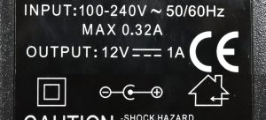 Detailaufnahme des Typenschilds eines Netzteils für 12 volt Gleichspannung bei max. 1 Ampere.